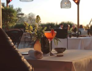 a table with a drink and a vase with a flower at Bella Vista Hôtel, Suites & Maisons in Porticcio