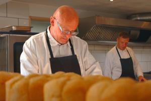 two men in a kitchen preparing bread at Bella Vista Hôtel, Suites & Maisons in Porticcio