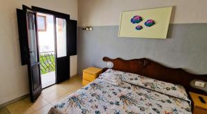 1 dormitorio con 1 cama con un edredón colorido en 3 Mini Studios in Siniscola, en Siniscola