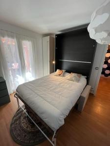 a bedroom with a large bed with a black headboard at Studio indépendant avec hammam in Montpellier +16 photos