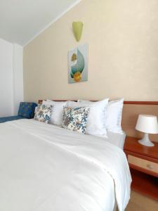 Albatros 2 Family Hotel في كيتن: غرفة نوم بسرير ابيض مع مخدات