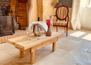 a table with wine glasses on it in a living room at La Chambre du Clos - Meursault in Meursault