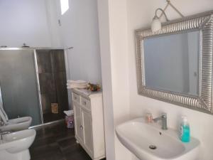 bagno con lavandino, servizi igienici e specchio di Casa da rosellina a Carini