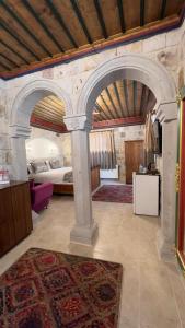 a room with an archway with a bed and a rug at Elysee Cave House in Goreme