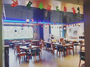 a dining room with tables and chairs and christmas decorations at Mehood Theater Hotel, Jinan High -tech Zone Wanda Plaza in Jinan +21 photos