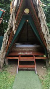une tente avec un lit dans l'herbe dans l'établissement Centro Ananda, à Guápiles
