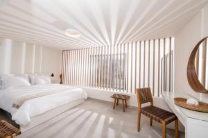 una camera da letto bianca con un letto grande e uno specchio di Serene Villas Halkidiki - Deluxe a Nea Iraklia