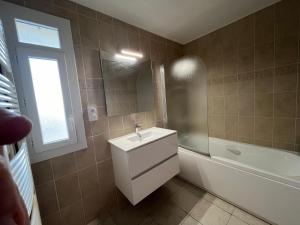 a bathroom with a sink and a bath tub at Skyview Appartement 4 Chambres in Valence