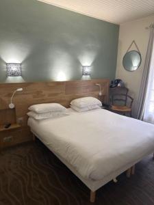 a bedroom with a large white bed with two pillows at Best Western Le Val Majour in Fontvieille