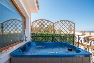 a blue tub on a balcony with a window at Casa di Cuore - Beachfront in Argasi