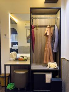 a room with a closet with a dress and a table at M&H Hotel in Ho Chi Minh City