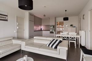 a living room with a white couch and a table at Villa Emilia 0206 P104 in Nieuwpoort