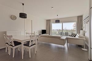 a white living room with a table and a couch at Villa Emilia 0206 P104 in Nieuwpoort