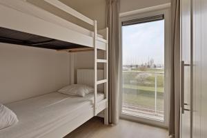 a bedroom with bunk beds and a large window at Villa Emilia 0206 P104 in Nieuwpoort +10 photos