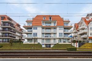 a building with an orange roof next to a train track at Villa Emilia 0206 P104 in Nieuwpoort