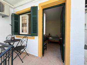 an open door to a patio with a table and chairs at Antigone's Studio in Kassiopi +3 photos