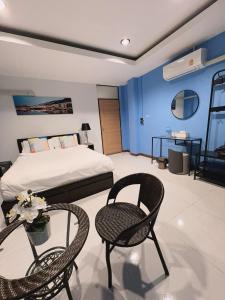 Un dormitorio con una cama y dos sillas y una mesa. en Noc House, en Bang Khlo