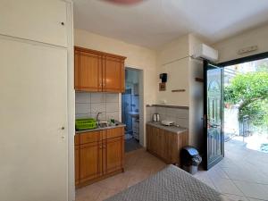 a kitchen with wooden cabinets and a sink at Antigone's Studio in Kassiopi
