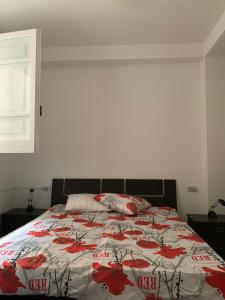 a bedroom with a bed with red flowers on it at VILLA MARELUNA - near the beach , family residence pet friendly ! in Capo Vaticano