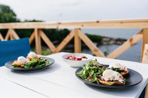 zwei Teller Essen auf einem Tisch mit Salat in der Unterkunft PARADISE Bay Hotel in Sozopol