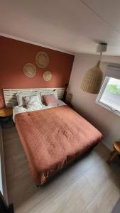 a small bedroom with a bed with an orange blanket at Family vibes, op 5 sterren vakantiepark in Limburg in Sevenum
