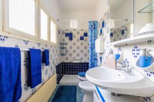 a blue and white bathroom with a sink and a toilet at Sweet Honey Home by Halldis in Dongo +37 photos