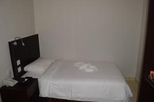 a bedroom with a bed with a white blanket at Hotel Desaru Penawar in Desaru