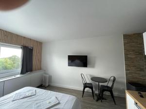 1 dormitorio con 1 cama, mesa y sillas en Appartement design tout confort (parking gratuit), en Gradignan
