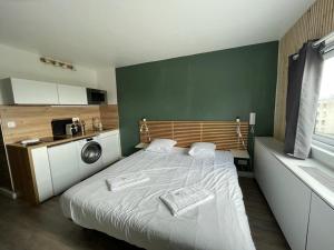 1 dormitorio pequeño con 1 cama y cocina en Appartement design tout confort (parking gratuit), en Gradignan