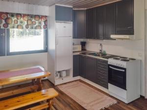 RuvaslahtiにあるHoliday Home Iltarauha by Interhomeのキッチン(黒いキャビネット、白いコンロ付)