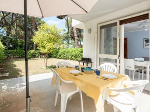 Holiday Home Casa Polipo by Interhome في برانسيبينا أو ماري: طاولة طعام مع كراسي بيضاء ومظلة