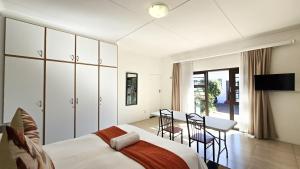 una camera da letto con un letto, un tavolo e delle sedie di H cottages a East London