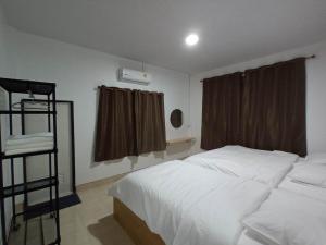 um quarto com uma cama branca e uma janela em JW Homestay Betong เจ ดับบลิว โฮมสเตย์ เบตง em Betong
