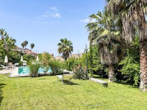 a lawn with a chair and a swimming pool at Apartment Il Risveglio by Interhome in Gorleri