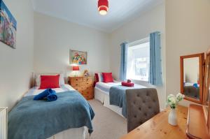 a bedroom with two beds and a window at Honeysuckle Cottage in Doddington