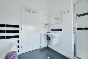 a white bathroom with a toilet and a sink at Honeysuckle Cottage in Doddington +31 photos