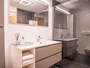 a white bathroom with a sink and a shower at Apartment Chesa Vadret Surlej by Interhome in Surlej