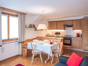 a kitchen with a white table and chairs in a room at Apartment Chesa Vadret Surlej by Interhome in Surlej