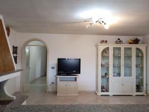 sala de estar con TV y armario blanco en Casa vacanze da viola, en Ugento