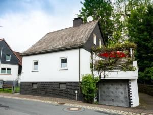 a white and black house with a garage at Holiday Home Neles Kate am Diemelsee by Interhome in Helminghausen