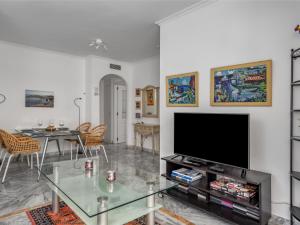 a living room with a flat screen tv and a table at Apartment Lorcrisur by Interhome in Marbella