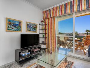 a living room with a tv and a glass table at Apartment Lorcrisur by Interhome in Marbella