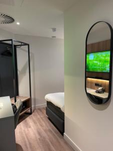 um quarto com um espelho, uma cama e uma mesa em OZO Hotels Antares Airport em Hoofddorp