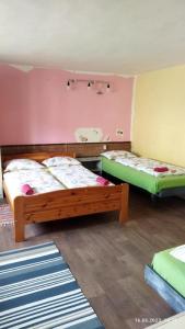 - 2 lits dans une chambre rose et verte dans l'établissement Lucky Kitten , High Tatras, à Nová Lesná