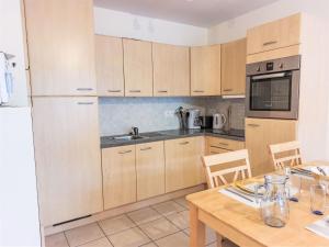 a kitchen with wooden cabinets and a wooden table at Apartment Domaine de Crespin-3 by Interhome in Saint-Gervais-les-Bains
