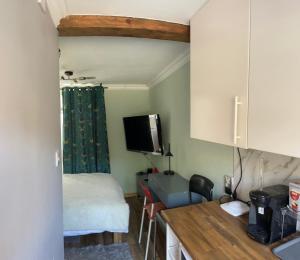 Cette petite chambre comprend un lit et une cuisine avec une table. dans l'établissement Agnieszka Dabrowska, à Teversham