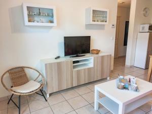 a living room with a tv and a chair and a table at Apartment Domaine de Crespin-3 by Interhome in Saint-Gervais-les-Bains