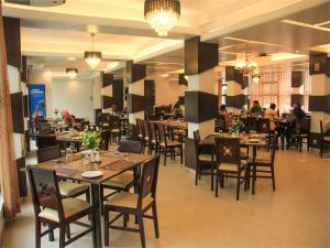 a restaurant with tables and chairs and people sitting at tables at Shada Pathor Hotel & Resort in Bholāganj