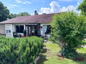 a house with a yard with bushes in front of it at Campanile L'Isle d'Abeau - Bourgoin Jallieu in LʼIsle-dʼAbeau