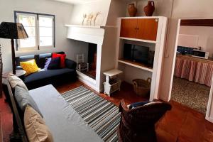 a living room with a couch and a fireplace at Alentempo in Aldeia de Brescos